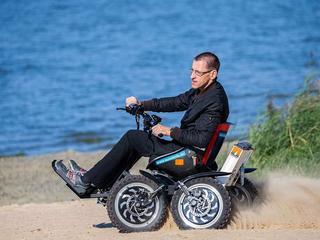 Ein Mann fährt mit dem motorisierten Rollstuhl "Zoom" über den Strand.